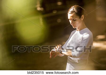 Woman checking wristwatch View Large Photo Image Stock Photography - Woman checking wristwatch. Fotosearch
