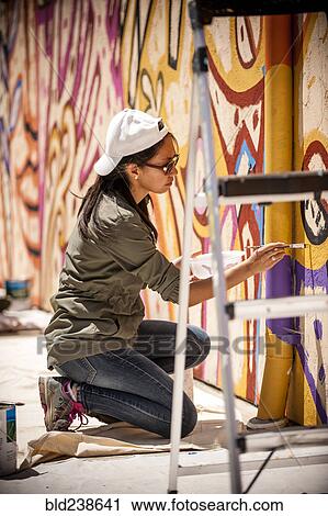 Woman kneeling on tarp painting mural on wall View Large Photo Image Stock Image - Woman kneeling on tarp painting mural on wall. Fotosearch