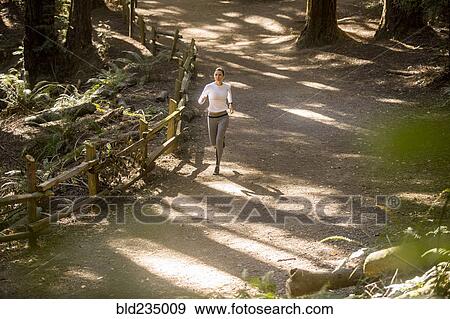 Stock Photo - Woman running on forest path. Fotosearch