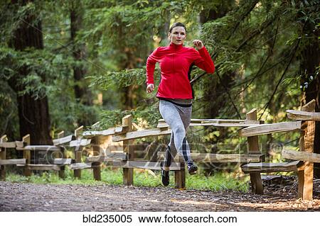 Stock Photography - Woman running on forest path. Fotosearch
