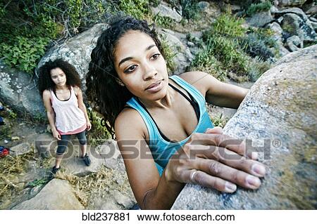 Woman watching friend rock climbing View Large Photo Image Stock Image - Woman watching friend rock climbing. Fotosearch