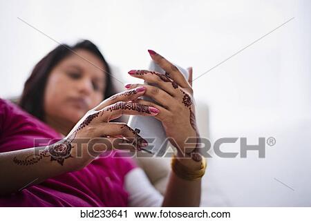 Woman with henna tattoos on hands texting on cell phone View Large Photo Image Stock Image - Woman with henna tattoos on hands texting on cell phone. Fotosearch