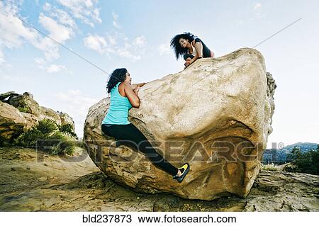 Women climbing on boulder View Large Photo Image Stock Image - Women climbing on boulder. Fotosearch