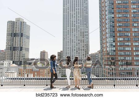 Women drinking wine on urban rooftop View Large Photo Image Stock Image - Women drinking wine on urban rooftop. Fotosearch