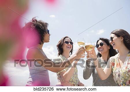 Stock Photograph - Women drinking wine outdoors. Fotosearch