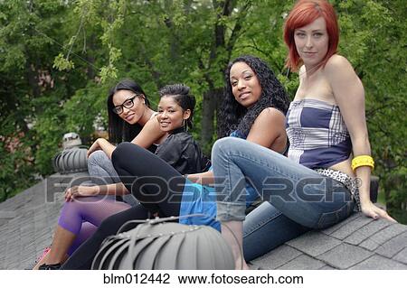 Women hanging out together on rooftop View Large Photo Image Stock Image - Women hanging out together on rooftop. Fotosearch