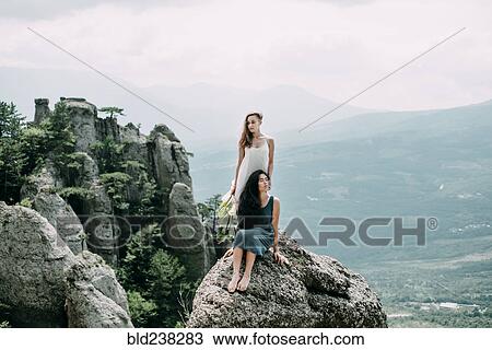 Women on rock overlooking landscape View Large Photo Image Stock Image - Women on rock overlooking landscape. Fotosearch