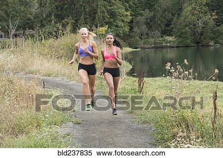 Women running on park path near lake View Large Photo Image Stock Photography - Women running on park path near lake. Fotosearch