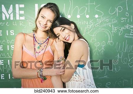 Women smiling near green chalkboard View Large Photo Image Stock Image - Women smiling near green chalkboard. Fotosearch