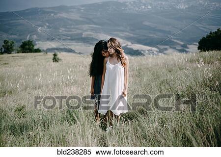 Stock Photography - Women standing in field of tall grass. Fotosearch