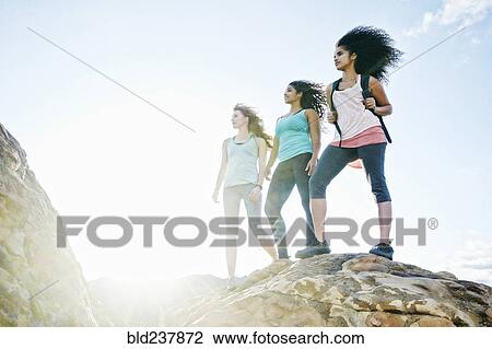 Stock Image - Women standing on rock. Fotosearch