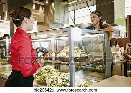 Worker assisting businesswoman in food court View Large Photo Image Stock Photography - Worker assisting businesswoman in food court. Fotosearch
