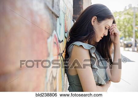 Worried Thai woman leaning on wall in city View Large Photo Image Stock Photograph - Worried Thai woman leaning on wall in city. Fotosearch