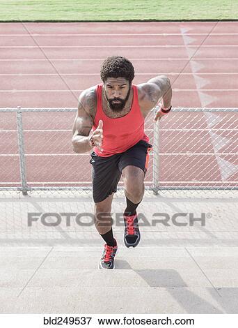 Stock Photo - African American man running on bleachers. Fotosearch