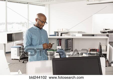 African American man texting on cell phone in office View Large Photo Image Stock Image - African American man texting on cell phone in office. Fotosearch