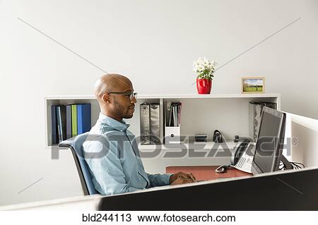 Stock Image - African American man using computer in office. Fotosearch