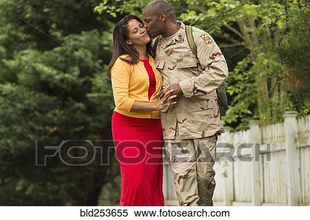 Stock Photography - African American soldier kissing wife on cheek. Fotosearch