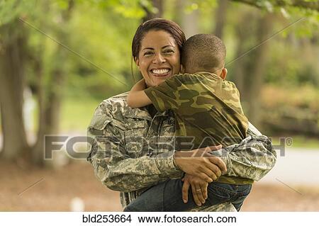 Picture - African American soldier mother carrying and hugging son. Fotosearch