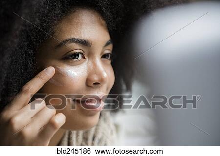 African American woman applying lotion to face View Large Photo Image Stock Photograph - African American woman applying lotion to face. Fotosearch