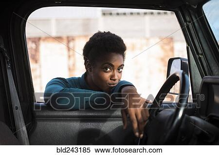 Stock Photography - African American woman leaning on car window. Fotosearch