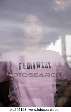 African American woman wearing feminist t-shirt behind window View Large Photo Image Stock Image - African American woman wearing feminist t-shirt behind window. Fotosearch