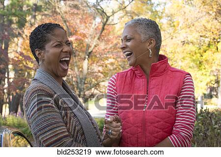African American women holding hands and laughing outdoors View Large Photo Image Stock Photo - African American women holding hands and laughing outdoors. Fotosearch