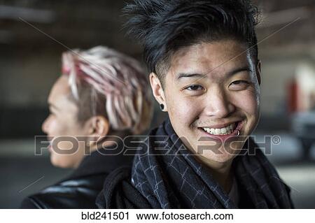 Stock Image - Androgynous Asian man and woman back to back. Fotosearch