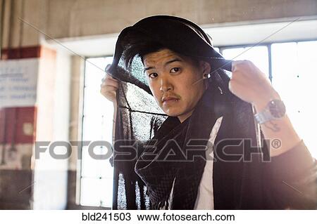 Androgynous Asian man holding scarf on head View Large Photo Image Stock Image - Androgynous Asian man holding scarf on head. Fotosearch