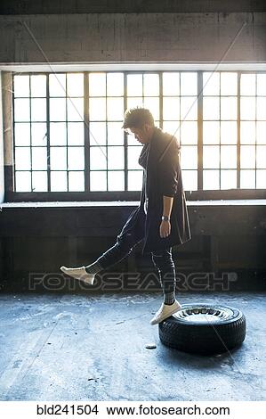 Androgynous Asian man standing on wheel View Large Photo Image Picture - Androgynous Asian man standing on wheel. Fotosearch