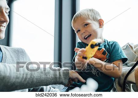 Arm of mother tickling son holding toy car View Large Photo Image Stock Photograph - Arm of mother tickling son holding toy car. Fotosearch