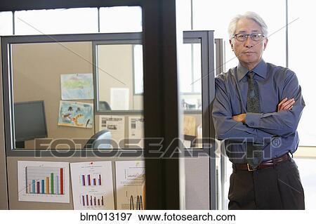 Asian businessman leaning on office cubicle View Large Photo Image Stock Photo - Asian businessman leaning on office cubicle. Fotosearch