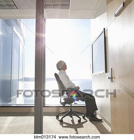 Picture - Asian businessman looking at monitor in conference room. Fotosearch