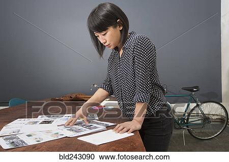 Asian businesswoman examining paperwork View Large Photo Image Stock Image - Asian businesswoman examining paperwork. Fotosearch