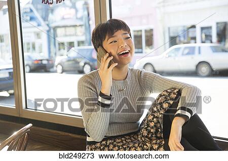 Asian teenage girl talking on cell phone on window sill View Large Photo Image Stock Image - Asian teenage girl talking on cell phone on window sill. Fotosearch