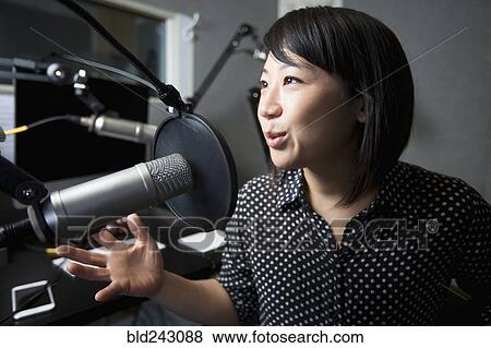 Stock Photo - Asian woman talking into microphone. Fotosearch