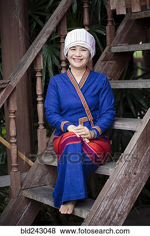 Stock Photo - Asian woman wearing traditional clothing sitting on staircase. Fotosearch
