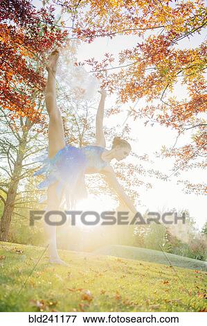Back lit Caucasian ballerina dancing under branches in park View Large Photo Image Stock Photo - Back lit Caucasian ballerina dancing under branches in park. Fotosearch