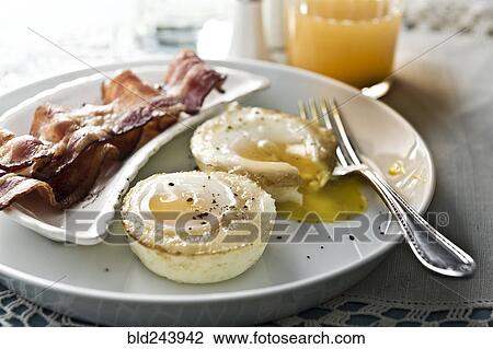 Stock Image - Baked eggs with bacon and juice. Fotosearch