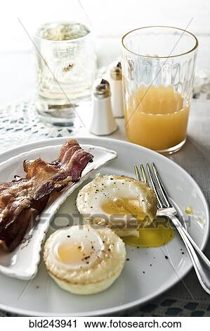 Stock Image - "Baked eggs with bacon, juice and champagne". Fotosearch