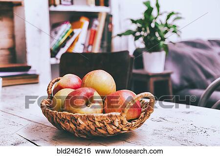 Basket of apples on wooden table in livingroom View Large Photo Image Stock Photograph - Basket of apples on wooden table in livingroom. Fotosearch