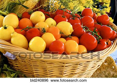 Stock Photograph - Basket of fresh lemons and tomatoes at market. Fotosearch