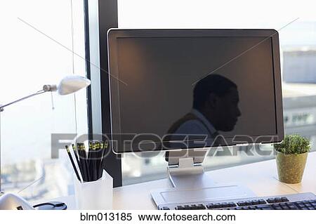 Stock Photography - Black businessman sitting at desk. Fotosearch