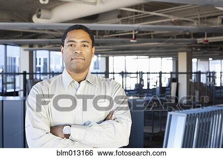 Stock Photograph - Black businessman standing in new office. Fotosearch