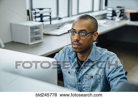 Stock Photo - Black businessman using computer. Fotosearch
