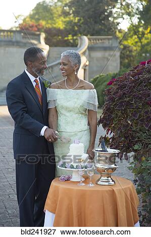 Black couple cutting wedding cake View Large Photo Image Stock Photo - Black couple cutting wedding cake. Fotosearch