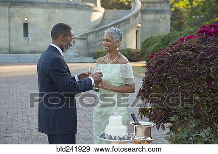 Black couple drinking champagne near wedding cake View Large Photo Image Stock Photo - Black couple drinking champagne near wedding cake. Fotosearch