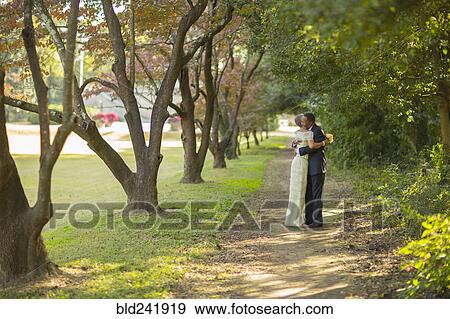 Stock Photo - Black couple hugging on path in park. Fotosearch