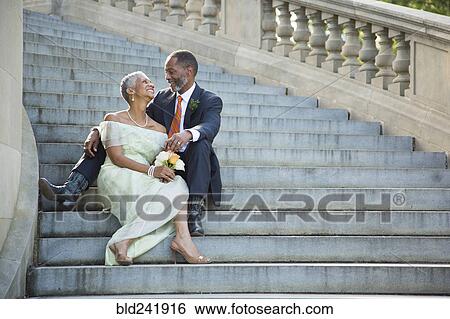 Stock Photograph - Black couple sitting on stone staircase. Fotosearch