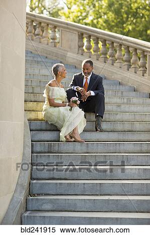 Stock Photography - Black couple sitting on stone staircase. Fotosearch