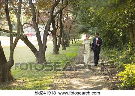 Black couple walking on path in park View Large Photo Image Stock Photo - Black couple walking on path in park. Fotosearch